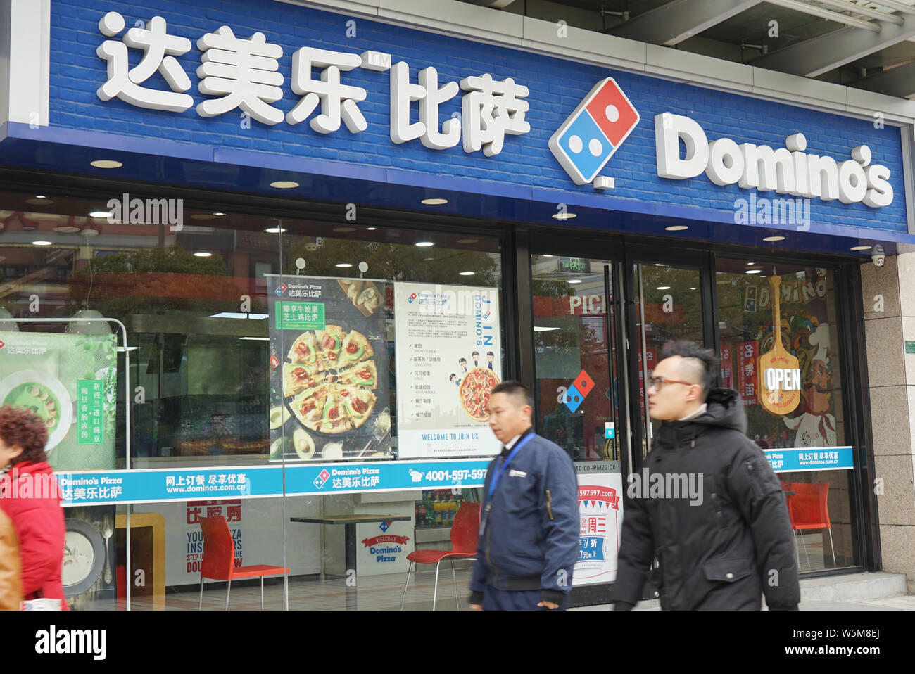 --FILE--pedoni a piedi passato ci una catena pizza Domino in Cina a Shanghai, 31 gennaio 2018. Domanda crescente da parte della generazione più giovane e incrementati o Foto Stock