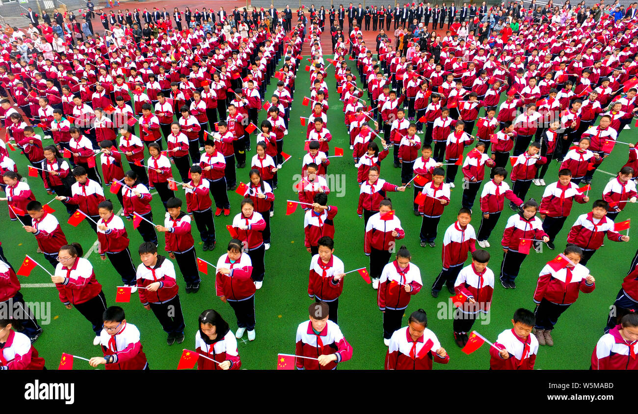Migliaia di studenti della scuola primaria si riuniranno presso un campo di calcio per il canto e la lode madre paese in Shenyang City, a nord-est della Cina di Liaoning provin Foto Stock