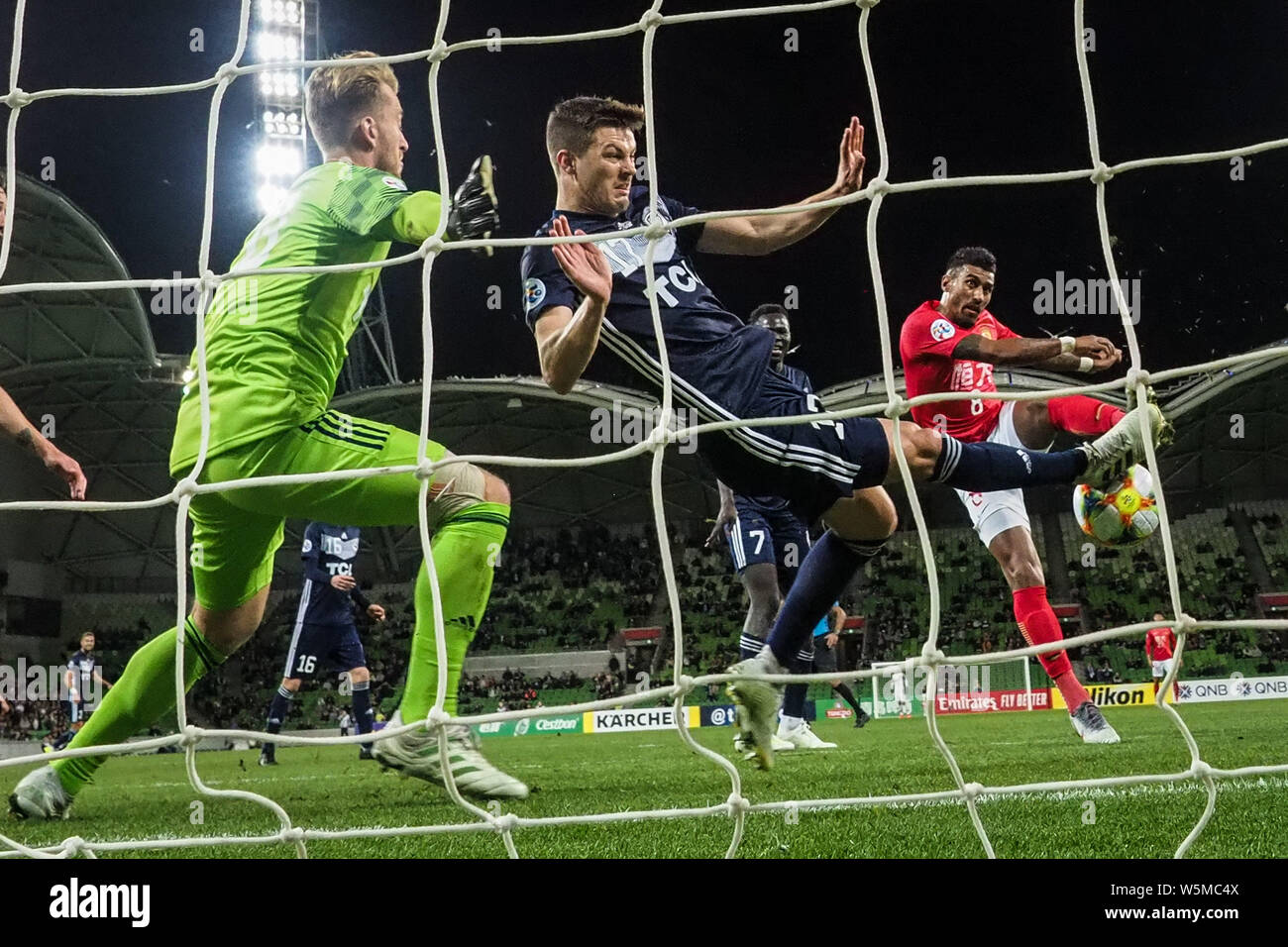 Il calcio brasiliano player Paulinho, a destra della Cina in Guangzhou Evergrande Taobao F.C. scatti la sfera contro giocatori di Australia Melbourne Vittoria Foto Stock