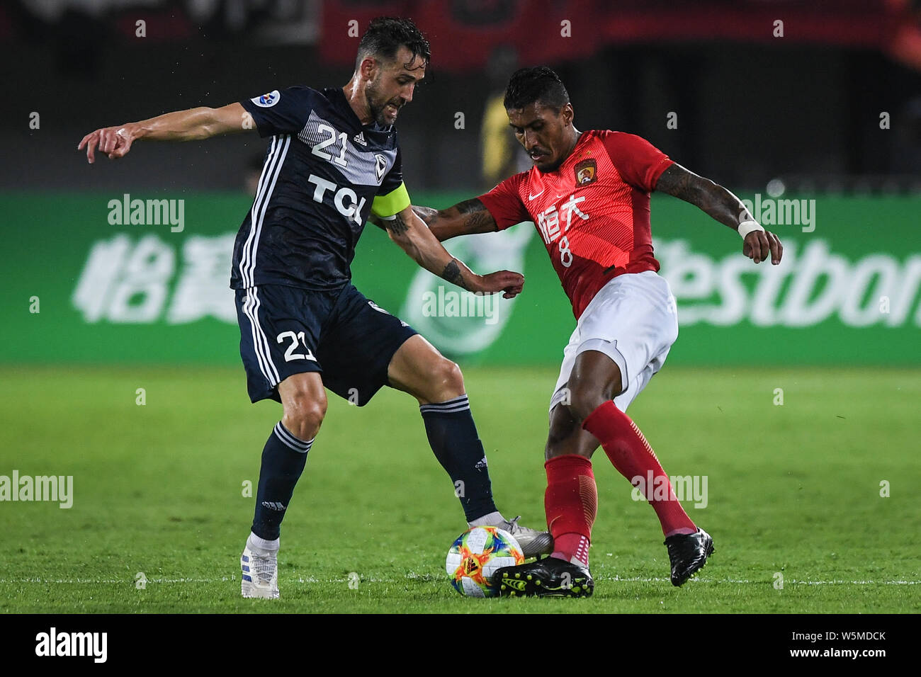 Il calcio brasiliano player Paulinho, a destra della Cina in Guangzhou Evergrande Taobao F.C., sfide Carl Valeri dell'Australia Melbourne vittoria FC dur Foto Stock