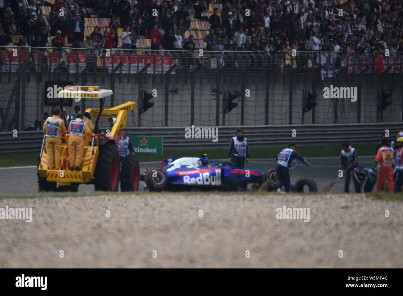 Lavoratori cerca di eliminare la vettura dopo Thai-British racing driver Alexander Albon della Scuderia Toro Rosso schiacciate durante l'ultima sessione di prove fo Foto Stock