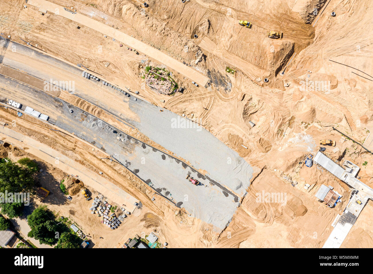 Antenna vista superiore di pesanti macchine da costruzione la costruzione di una nuova strada Foto Stock