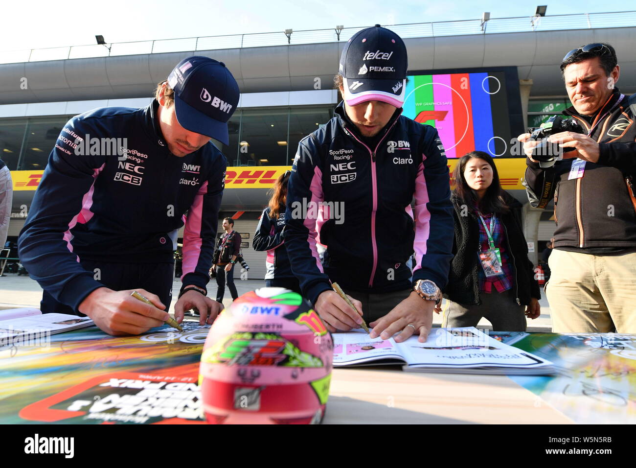 Mexican racing driver Sergio Perez, noto anche come "Checo' Perez, a destra del punto Racing segni sutographs davanti alla Formula 1 Heineken Chinese Grand Foto Stock