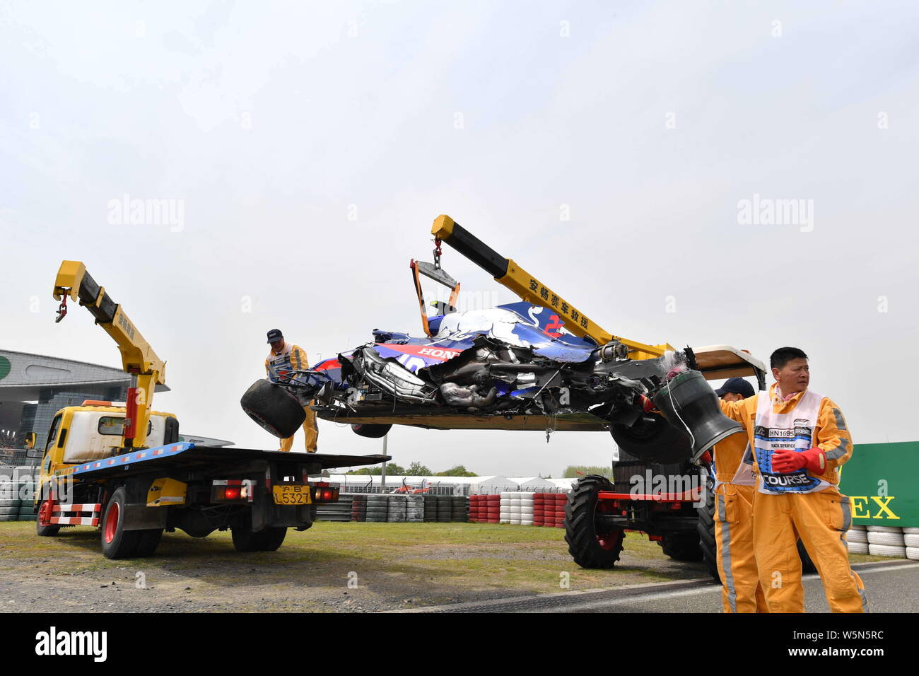 Lavoratori cerca di eliminare la vettura dopo Thai-British racing driver Alexander Albon della Scuderia Toro Rosso schiacciate durante l'ultima sessione di prove fo Foto Stock
