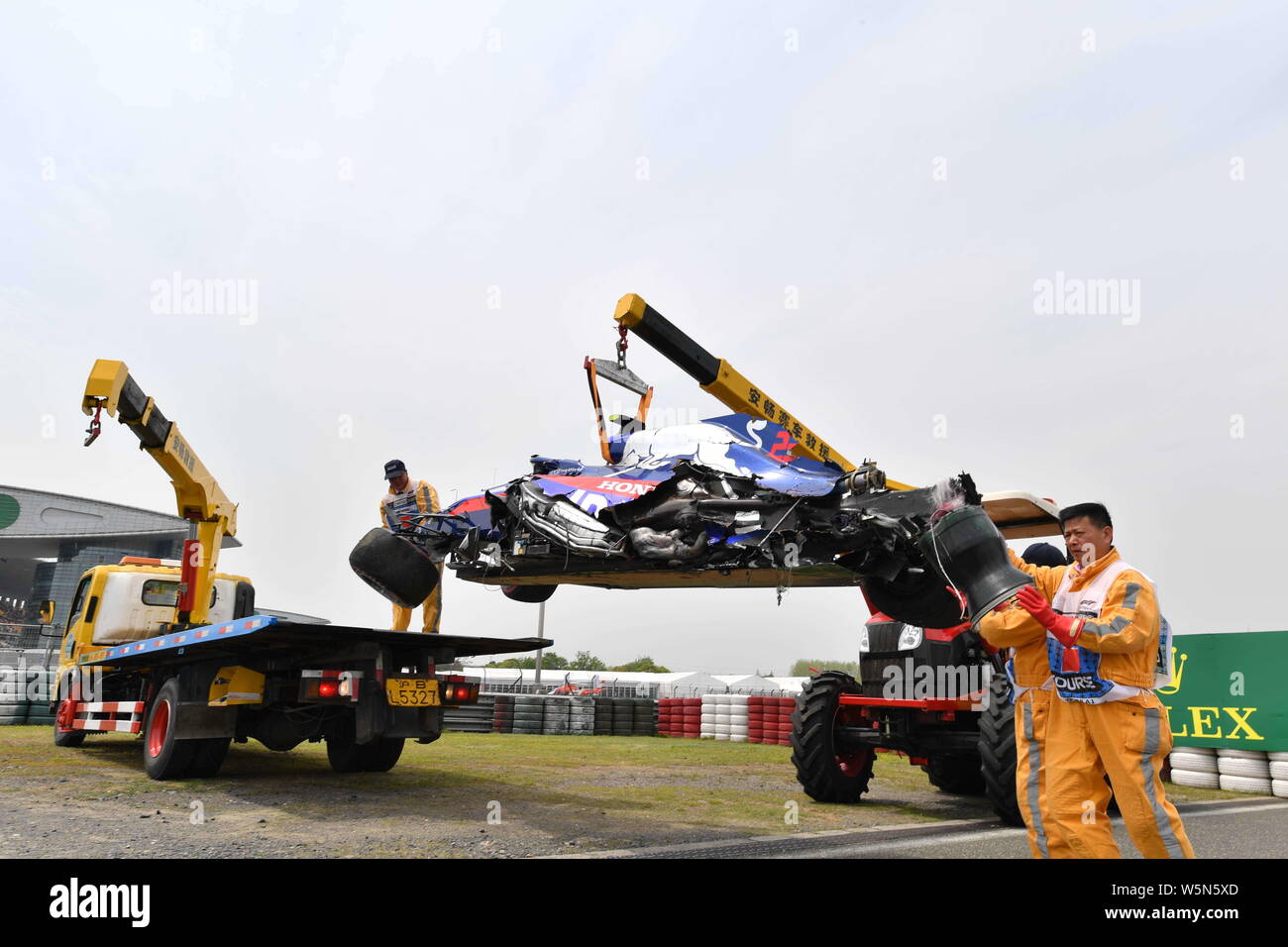 Lavoratori cerca di eliminare la vettura dopo Thai-British racing driver Alexander Albon della Scuderia Toro Rosso schiacciate durante l'ultima sessione di prove fo Foto Stock