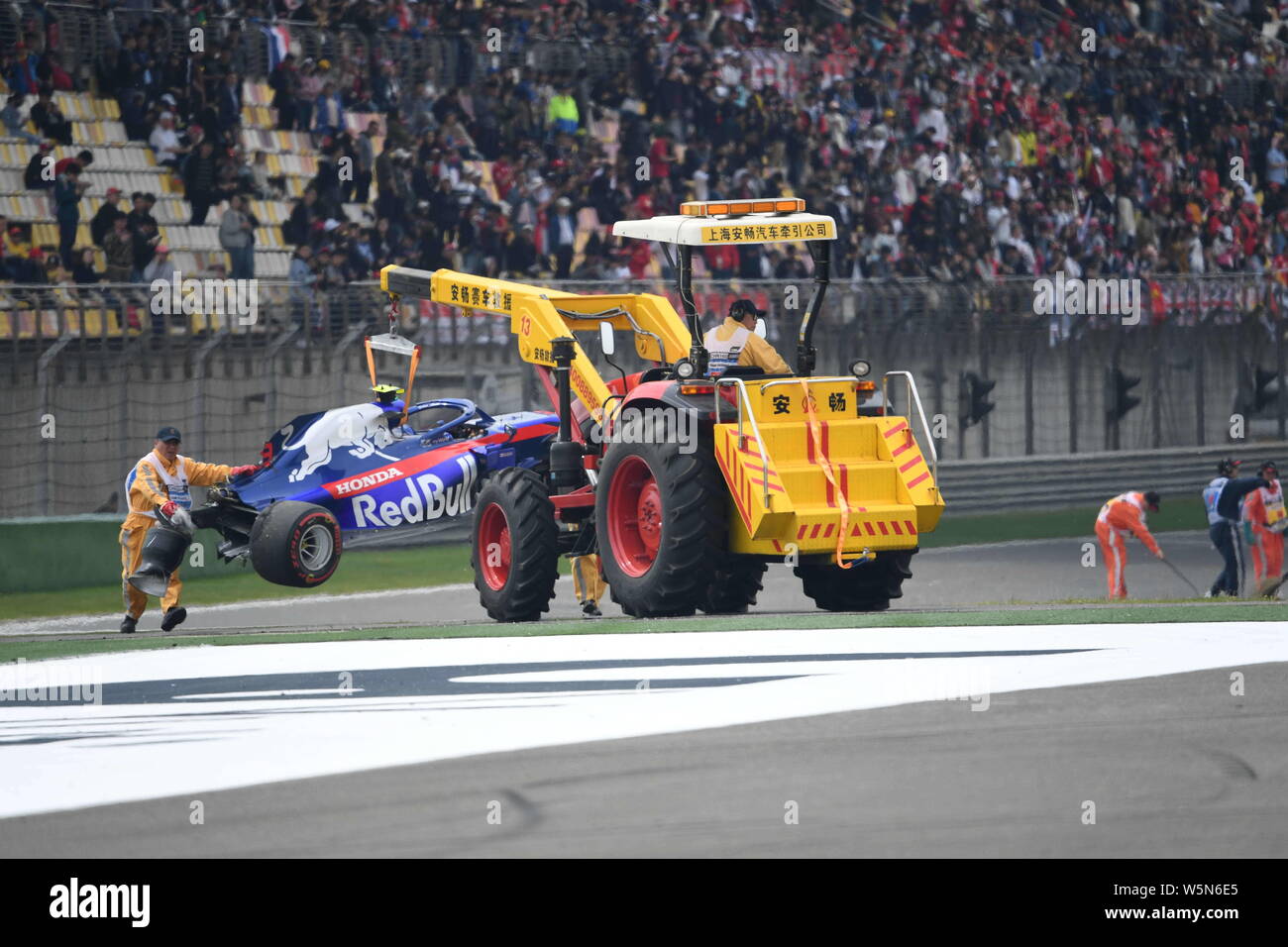 Lavoratori cerca di eliminare la vettura dopo Thai-British racing driver Alexander Albon della Scuderia Toro Rosso schiacciate durante l'ultima sessione di prove fo Foto Stock