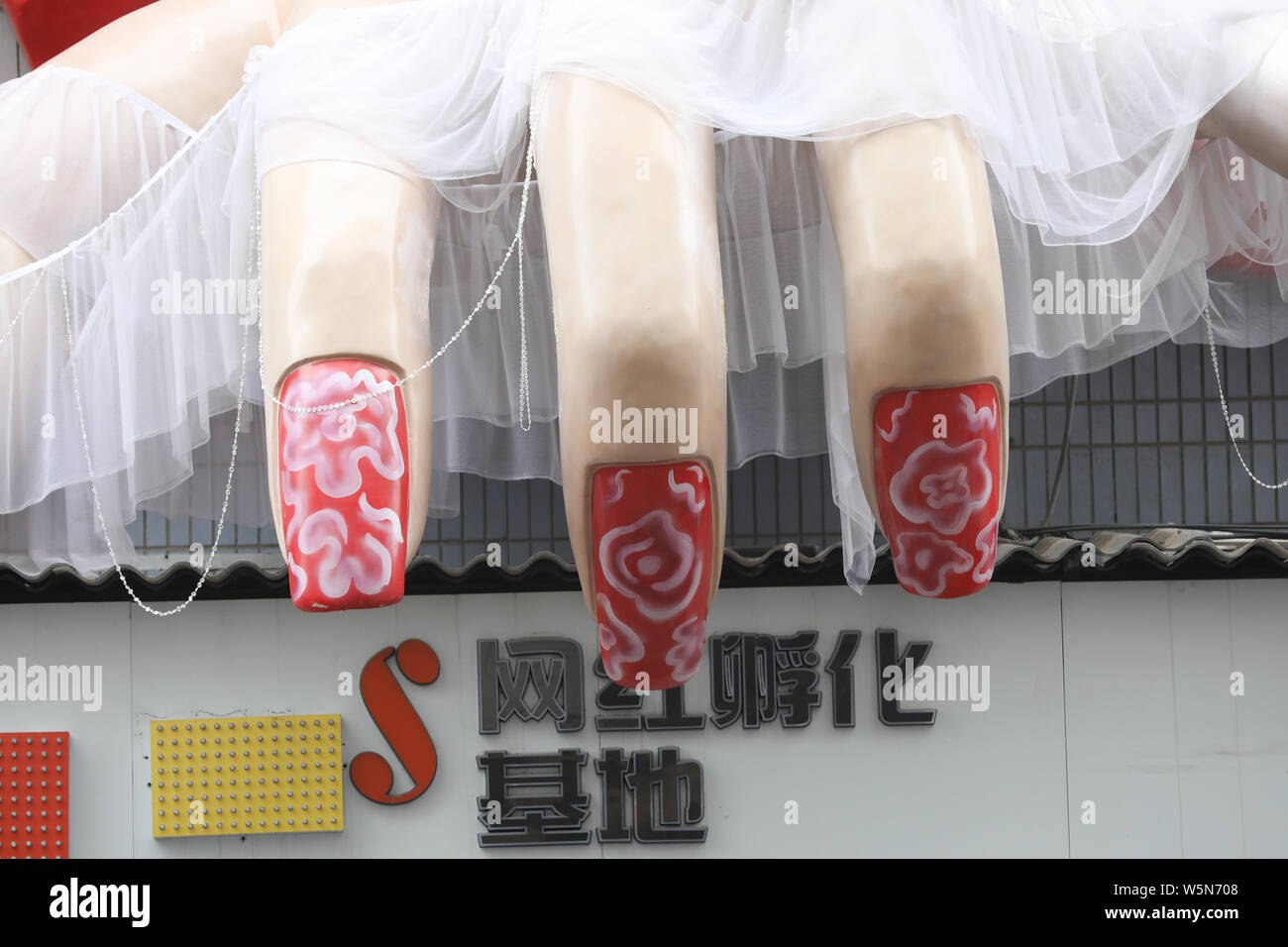 Un enorme scultura con la forma di una mano coperta con filo bianco è installato sulla superficie di un edificio a Xi'an City, a nord-ovest della Cina di Shaanxi Foto Stock