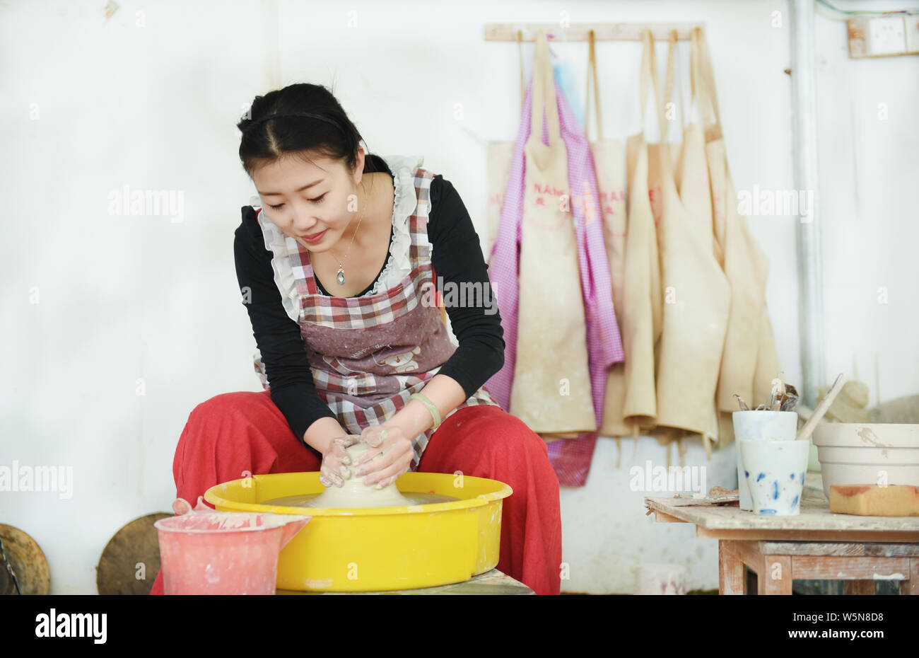 La porcellana cinese craftswoman Xu Shan rende porcellana e ceramica presso la sua officina nella città di Jingdezhen, Cina orientale della provincia di Jiangxi, 10 aprile 2019. Foto Stock