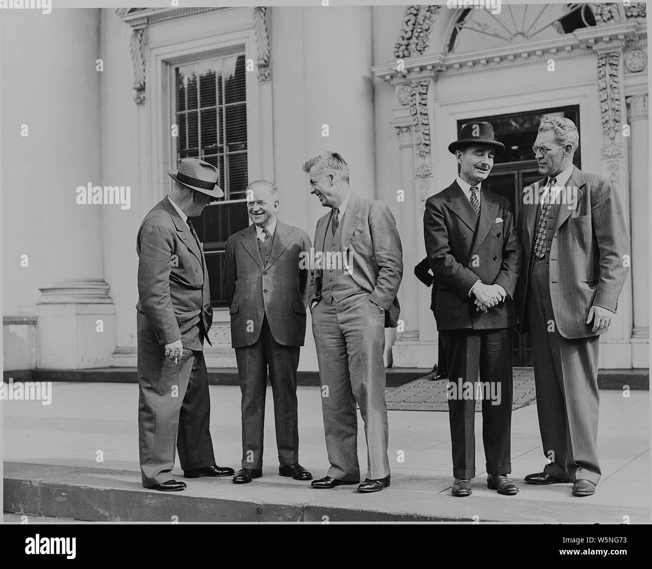 Harold L. Ickes, Henry A. Wallace e altri tre uomini stavano in piedi di fronte alla Casa Bianca nel corso di cerimonie che circonda la visita negli Stati Uniti del principe Abdul Ilah dell'Iraq. Foto Stock