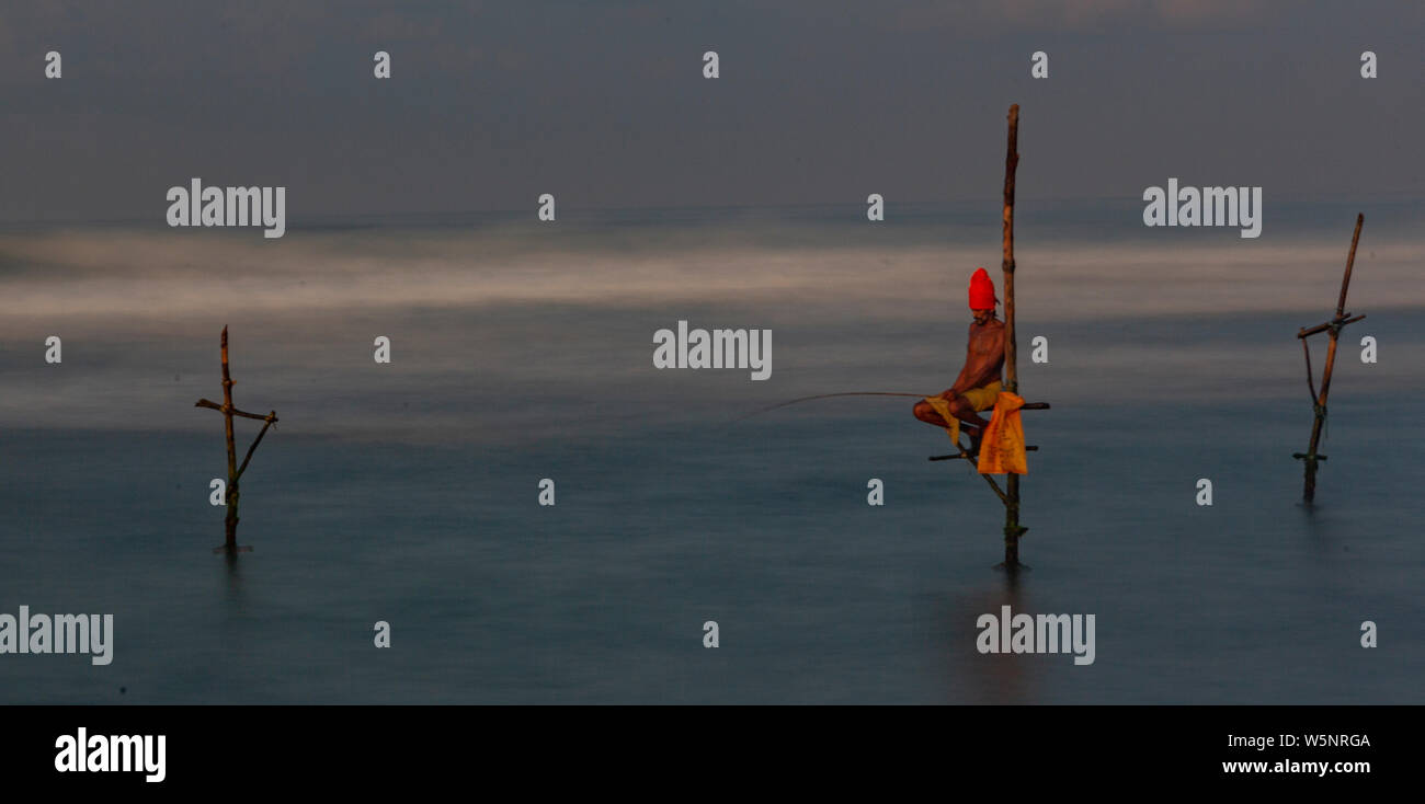 Galle, Sri Lanka - 2019-04-01 - Stilt pescatori dello Sri Lanka trascorrere tutto il giorno in piccole piattaforme a pescare per la cena. Foto Stock