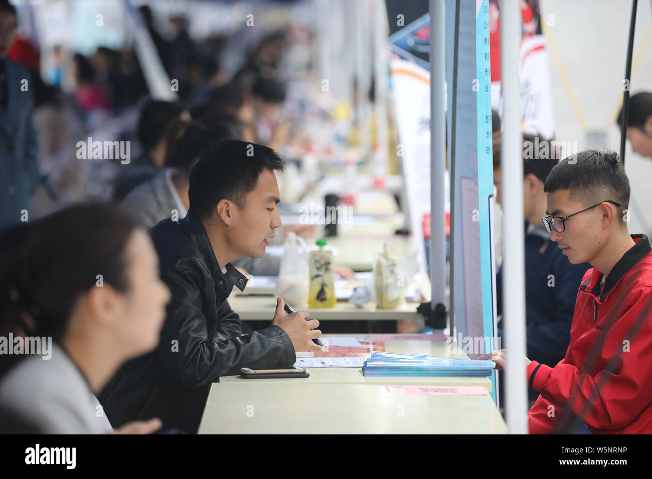 --FILE--laureati cinesi parla con intervistatori in cerca di occupazione a una fiera del lavoro a Xi'an Università Tecnologica di Xi'an City, Northwest C Foto Stock