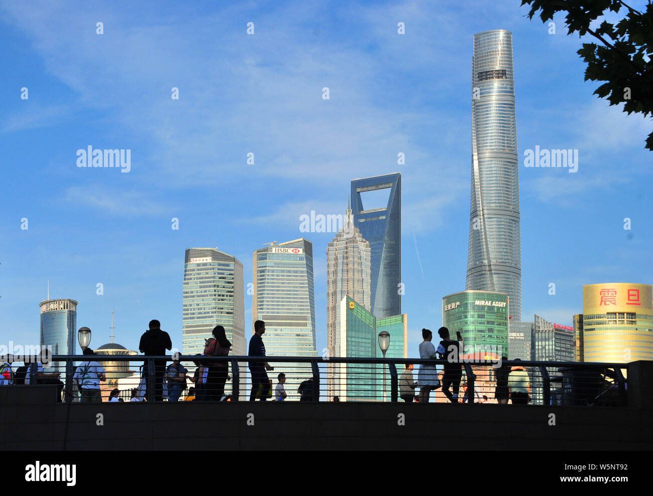 Turisti visitano la passeggiata sul Bund lungo il fiume Huangpu per visualizzare la Oriental Pearl TV Tower, più in alto a sinistra, la Shanghai Tower, diritto più alto, Foto Stock