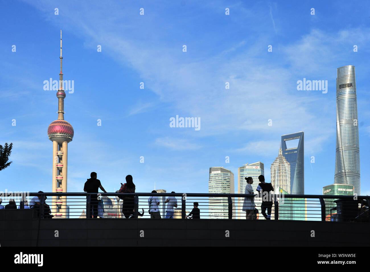 Turisti visitano la passeggiata sul Bund lungo il fiume Huangpu per visualizzare la Oriental Pearl TV Tower, più in alto a sinistra, la Shanghai Tower, diritto più alto, Foto Stock