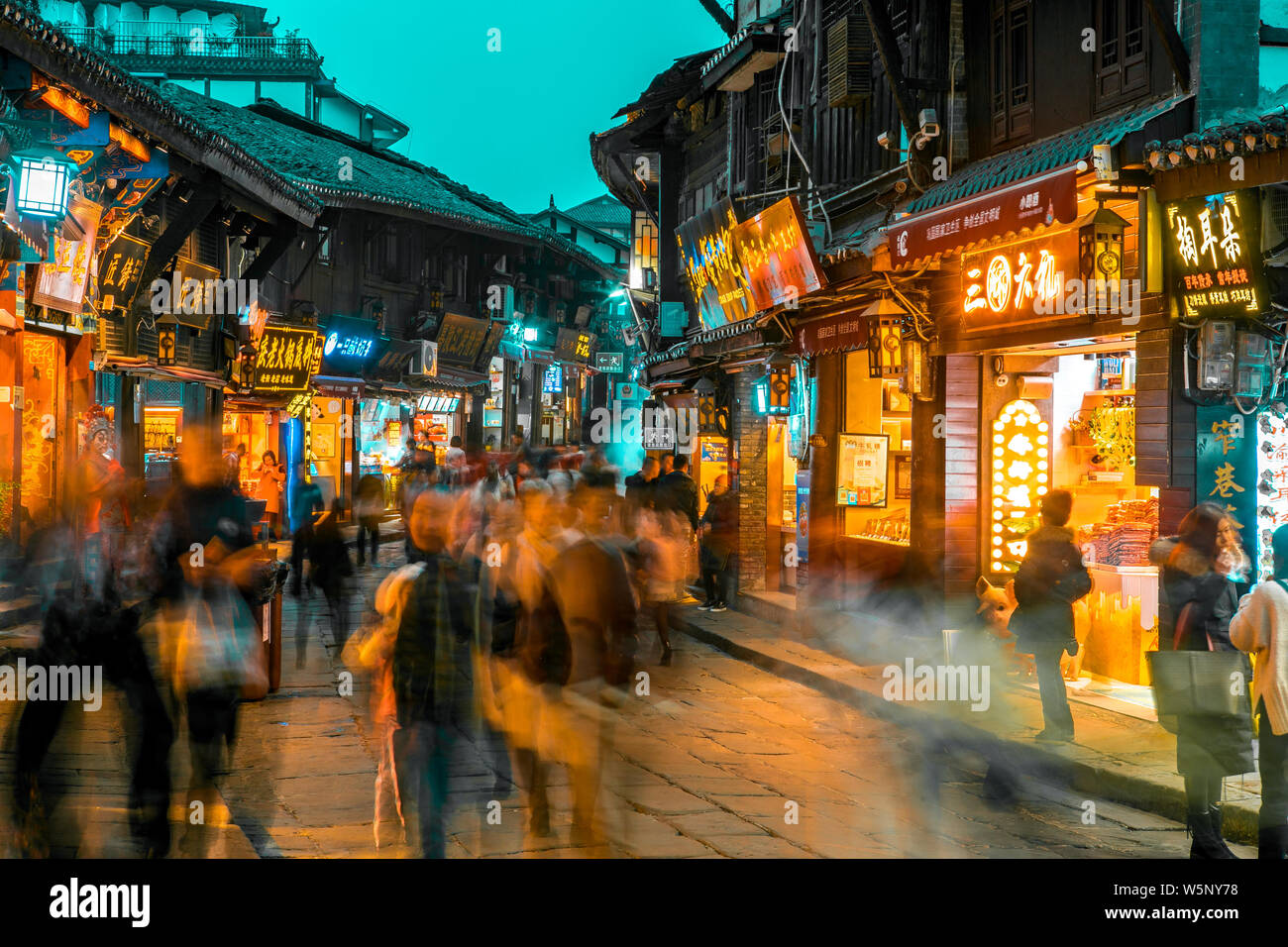 --FILE--turisti a piedi passato negozi lungo la strada in Ciqikou antica città, Chongqing, la Cina, il 13 dicembre 2018. Foto Stock