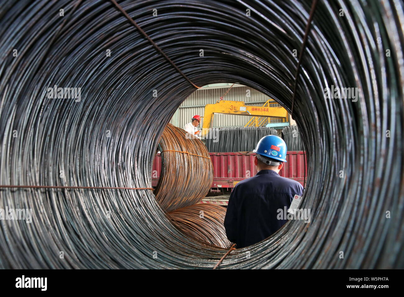 --FILE--un lavoratore cinese processi di pezzi in acciaio con un impianto nella città di Nantong, est cinese della provincia di Jiangsu, 3 luglio 2018. Della Cina di produzione di acciaio è f Foto Stock