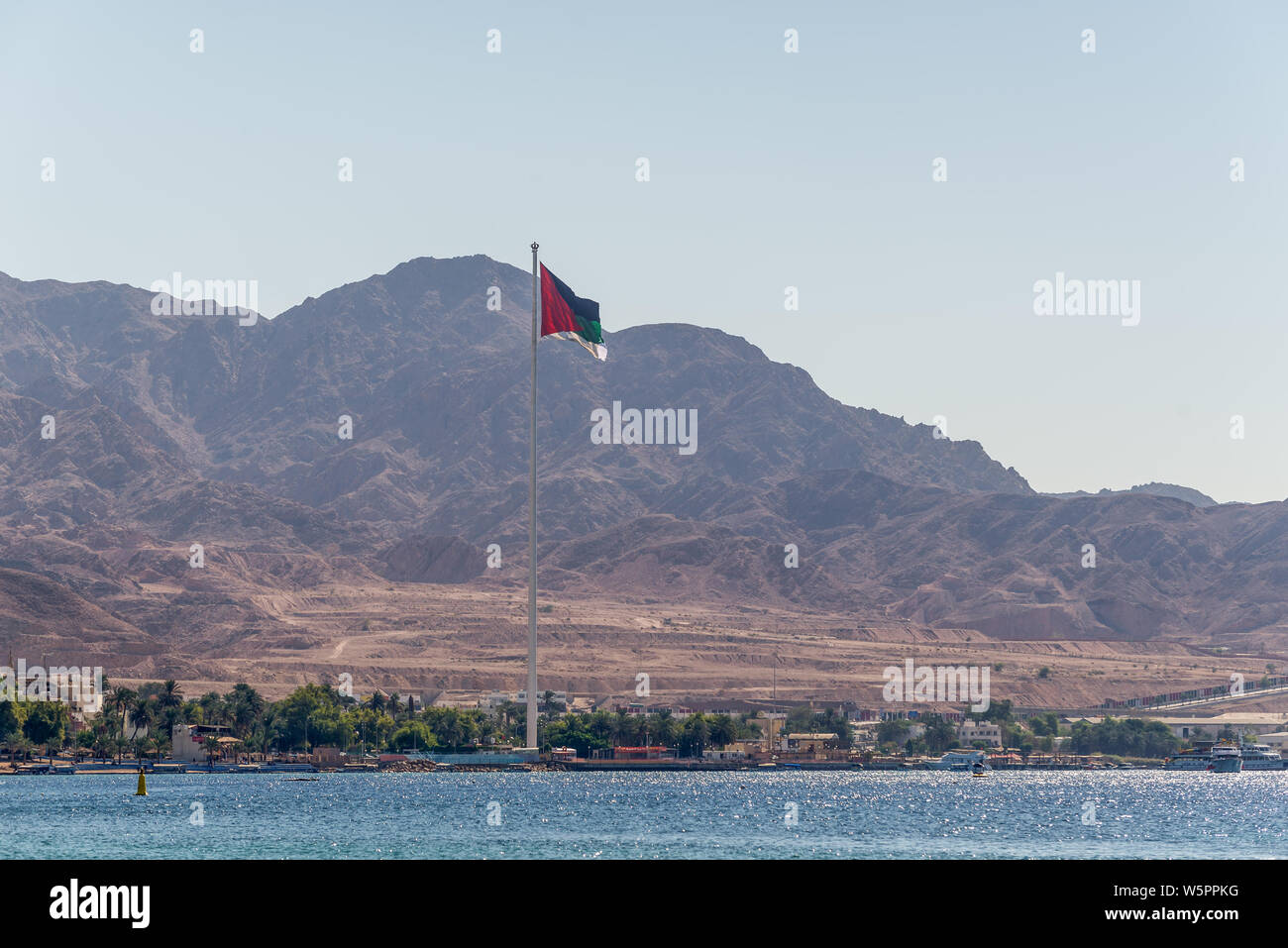 Aqaba Giordania - 6 Novembre 2017: Bandiera della Giordania sventolare sopra la città. Bandiera araba di Revolt-Sixth più alto pennone del mondo. Foto Stock
