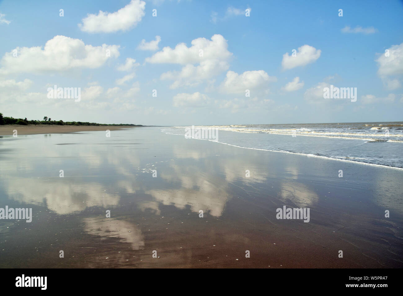 Nuvole bianche si riflette sulla spiaggia Bhagal Gujarat India Asia Foto Stock