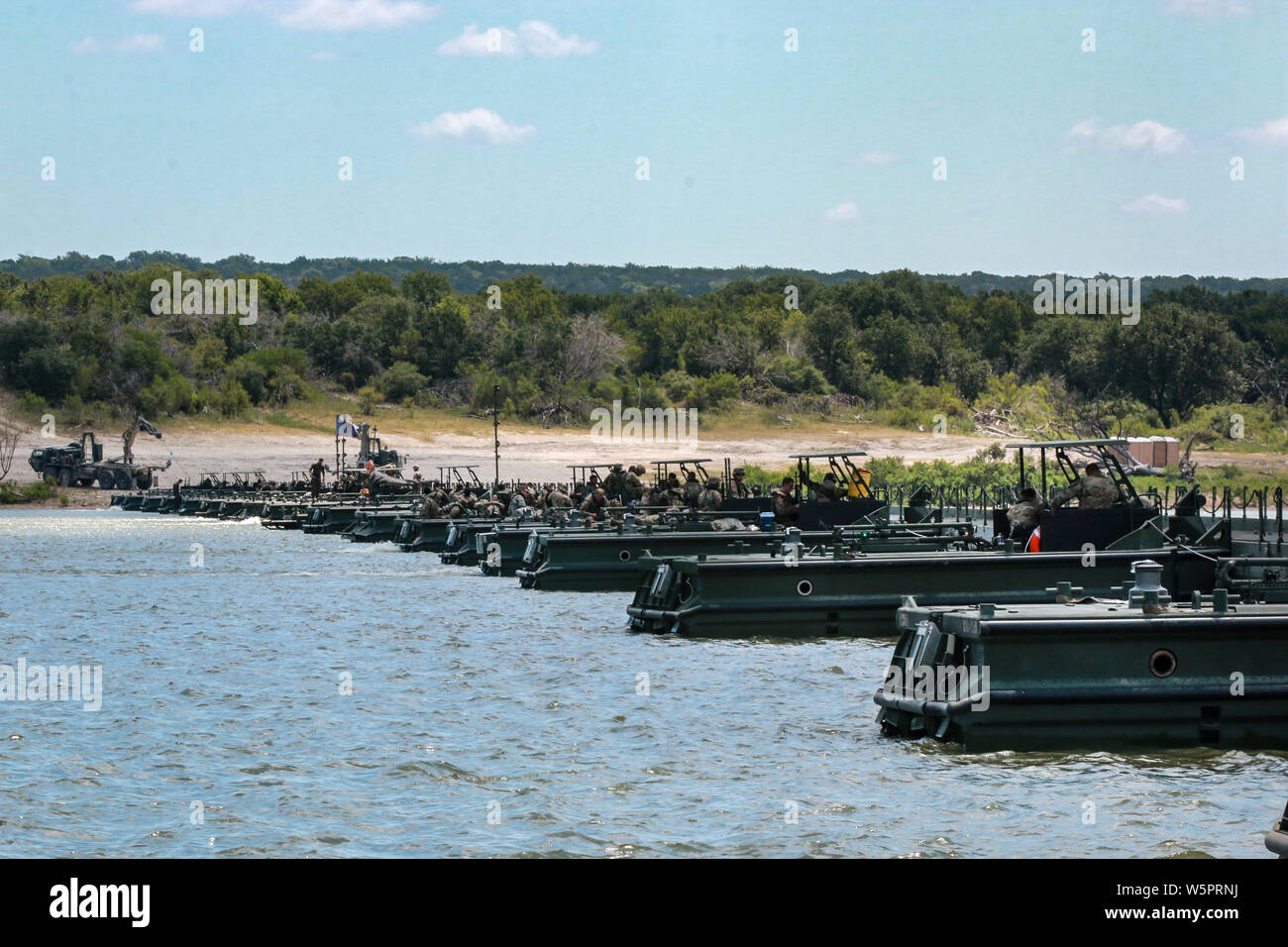 Servizio attivo dei soldati, soldati di riserva e riserva Marines hanno lavorato per più di quattro ore per completare e allegare un 72-bay galleggiante ponte chiamato nastro migliorate ponte (IRB) sul Lago Belton, durante le operazioni di ponte a Ft. Cappa, Texas a sostegno dell'esercizio fiume Assault 19 sulla luglio 23, 2019. L'IRB è un galleggiante, sistema pieghevole di chiatte che può essere usato come un intero intervallo bridge o traghetto veicoli ed attrezzature attraverso un corpo di acqua. Fiume Assault 19 è una chiave U.S. La riserva di esercito di esercizio che è destinato a ingegneri e facilitatori per condurre corsi di formazione specifici per aumentare readin Foto Stock