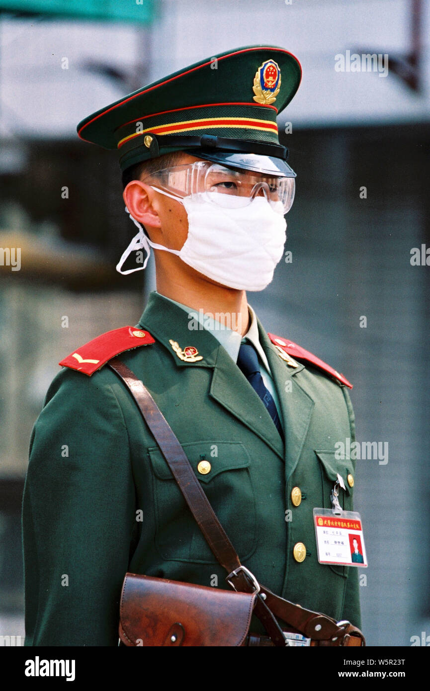 --FILE--un cinese di paramilitari poliziotto che indossa una maschera facciale per la prevenzione della SARS (sindrome respiratoria acuta grave) Sta di guardia sulla strada in Foto Stock