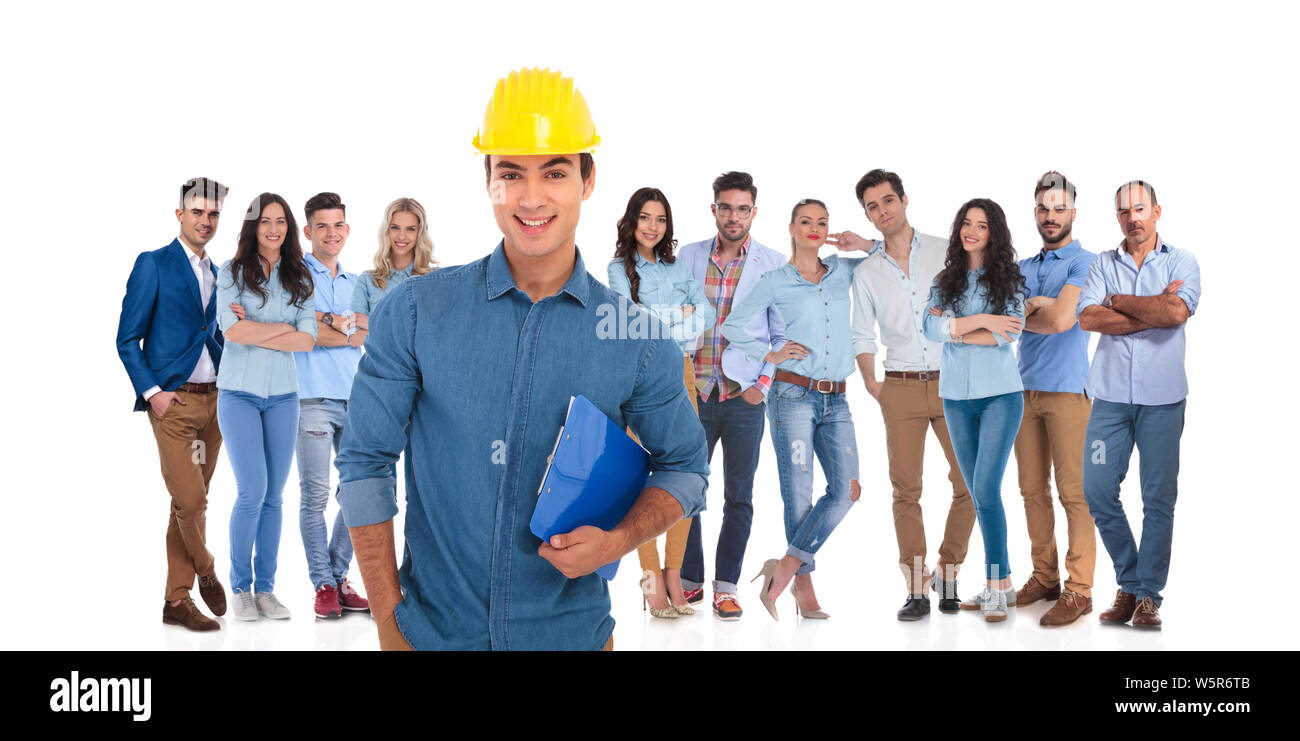 Ingegneria sorridente leader degli studenti tenendo premuto il Blocco note mentre il suo team informale è in piedi dietro di lui su sfondo bianco Foto Stock