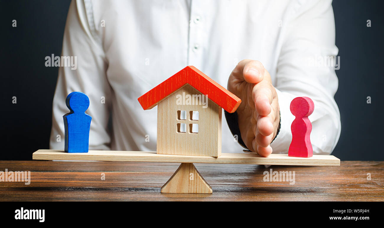 Un uomo con un palm separa la casa dalla moglie in favore del marito. La separazione della proprietà immobiliare divisione dopo il divorzio avvocato servizi. Foto Stock