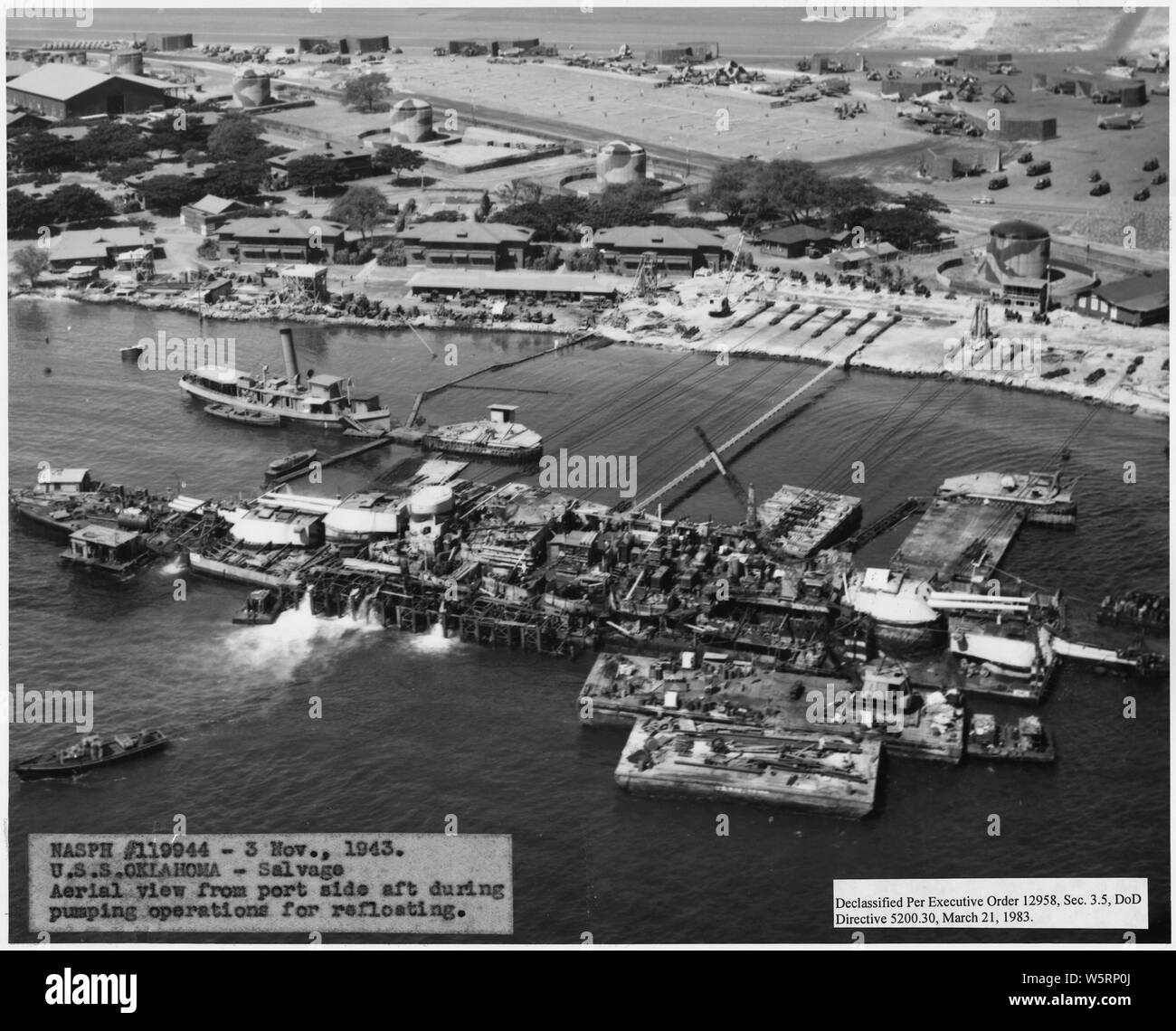 NASPH #119944- 3 Nov 1943; USS Oklahoma- Salvage- vista aerea dal lato della porta di poppa durante le operazioni di pompaggio per refloating; Portata e contenuto: questo è uno di una raccolta di fotografie di operazioni di salvataggio presso Pearl Harbor Naval Shipyard prese dal cantiere durante il periodo successivo all'attacco giapponese a Pearl Harbor che ha avviato la partecipazione degli Stati Uniti nella seconda guerra mondiale. Le fotografie sono trovati in un certo numero di file in diversi cantieri serie di record. Foto Stock