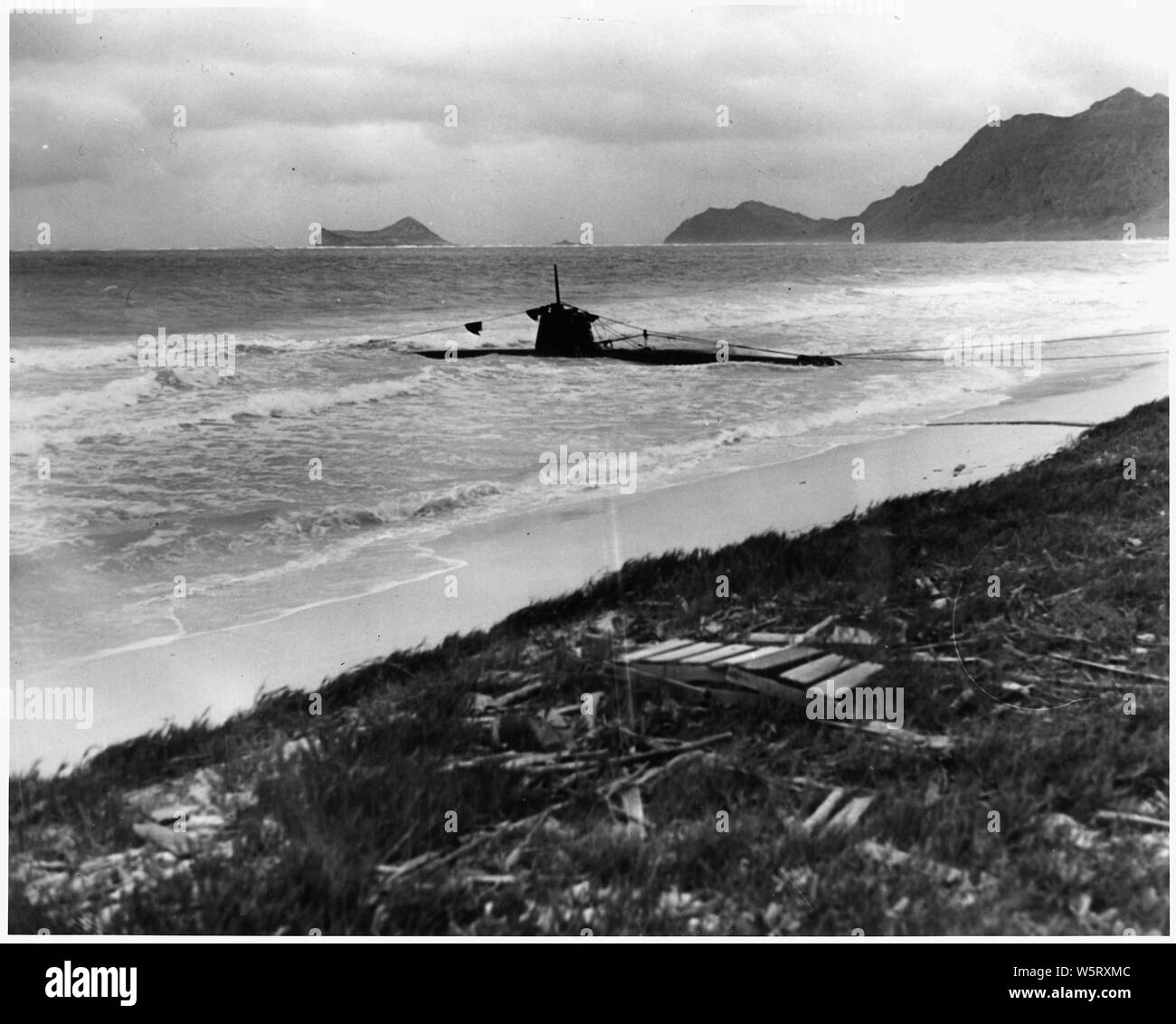 Fotografia navale di documentare l'attacco giapponese a Pearl Harbor, Hawaii che ha avviato la partecipazione degli Stati Uniti nella seconda guerra mondiale. La marina della didascalia: Una spiaggiata due-uomo sottomarino giapponese trovato sul bordo del campo a soffietto, Hawaii, dopo il jap sneak attacco a Pearl Harbor del 7 dicembre, 1941. orig. stampa.; Portata e contenuto: Questa fotografia è stata originariamente assunto da un fotografo navale immediatamente dopo l'attacco giapponese a Pearl Harbor, ma è venuto per essere archiviato in un atto di citazione di applicazione di habeas corpus caso (numero 298) cercato negli Stati Uniti la Corte distrettuale del distretto di Hawaii nel 1944. Il caso, nella ri Lloyd C. Dun Foto Stock