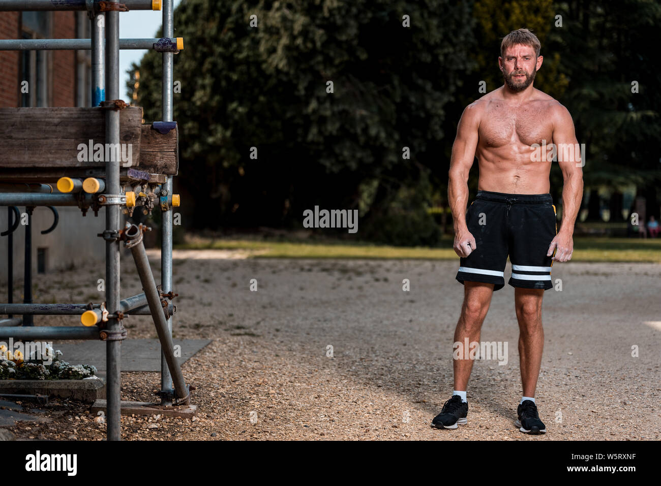 Montare l'uomo muscolare eseguendo calisthenics allenamento fitness sul  ponteggio all'aperto Foto stock - Alamy