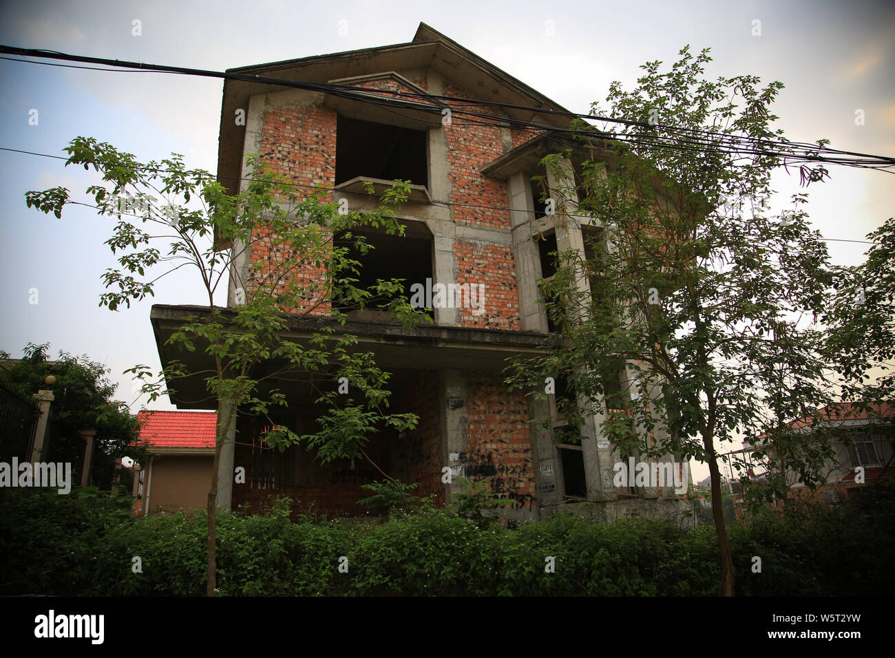 L'incompiuta ville sono ricoperti di erbacce e di altre piante verdi in Nanning city, a sud della Cina di Guangxi Zhuang Regione autonoma, 3 giugno 2019. Ro Foto Stock