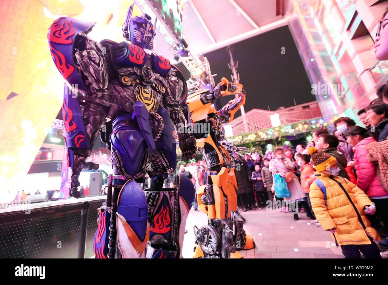 Uno studente di college che indossa un due-metro-high life-size replica di Megatron è circondato da clienti presso un centro commerciale per lo shopping a Xi'an City, a nord-ovest della Cina" Foto Stock