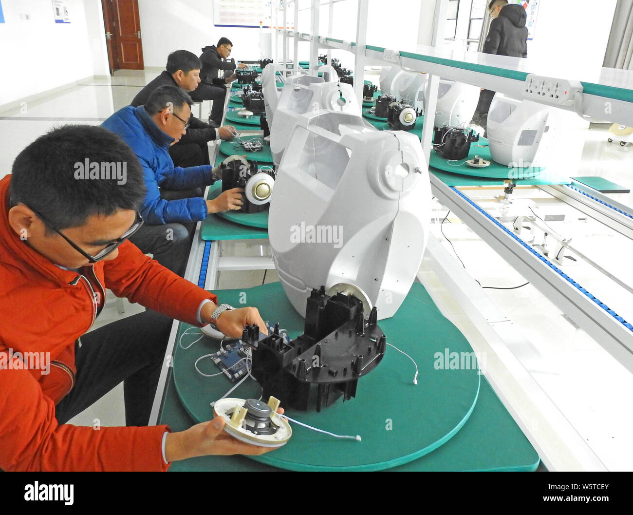 Lavoratori cinesi assemblare il servizio commerciale i robot al Haizhou lo sviluppo economico nella zona Lianyungang, est cinese della provincia di Jiangsu, 4 Dicembre Foto Stock