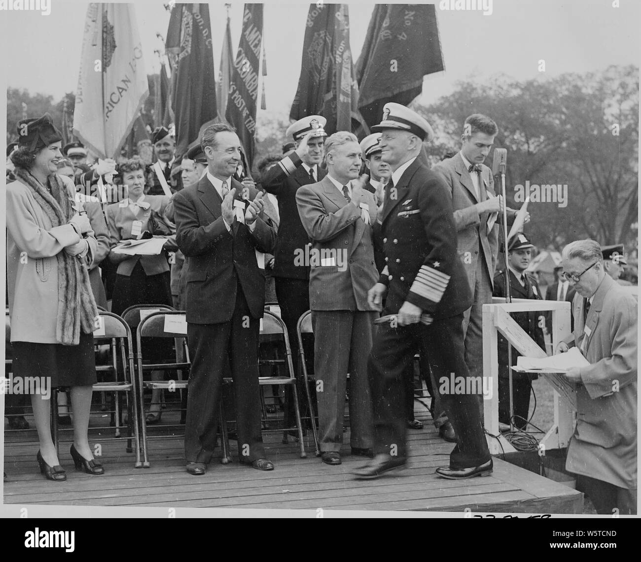 Fotografia di Admiral Chester Nimitz in arrivo su altoparlanti piattaforma, per gli applausi di dignitiaries. Foto Stock