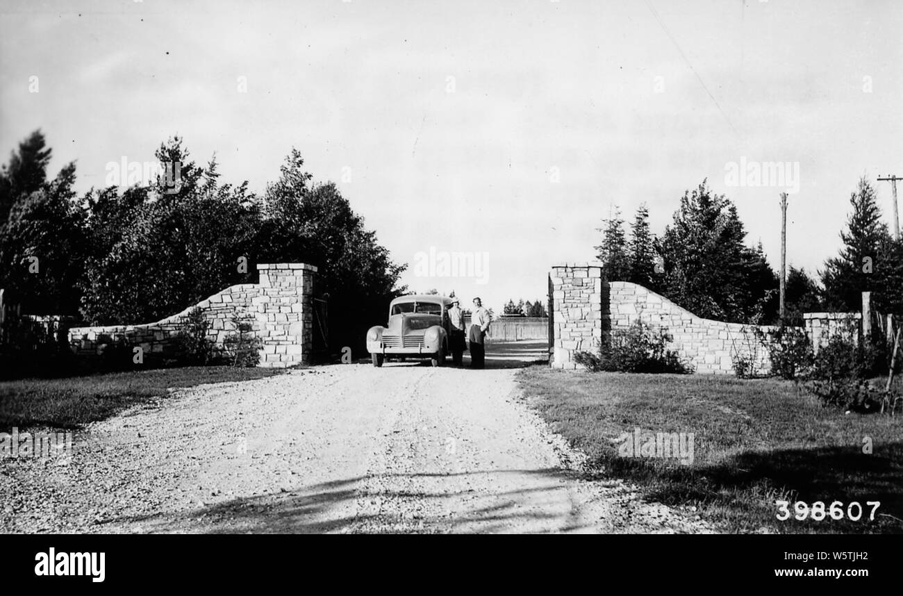 Fotografia di entrata a Wyman nursery, campo di applicazione e il contenuto: didascalia originale: ingresso a Wyman vivaio. Una buona progettazione e costruzione di entrata in pietra approfittando della struttura esistente di crescita. Le linee di utilità sono il solo occhio dolente. Foto Stock