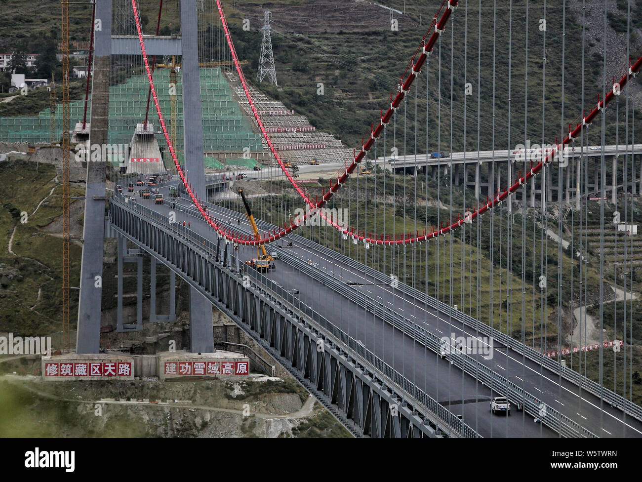 Il ponte Xingkangte su una superstrada che collega Ya'una città e contea di Kangding è sotto costruzione sopra il fiume Dadu in Luding county, Ganzi Tibeta Foto Stock