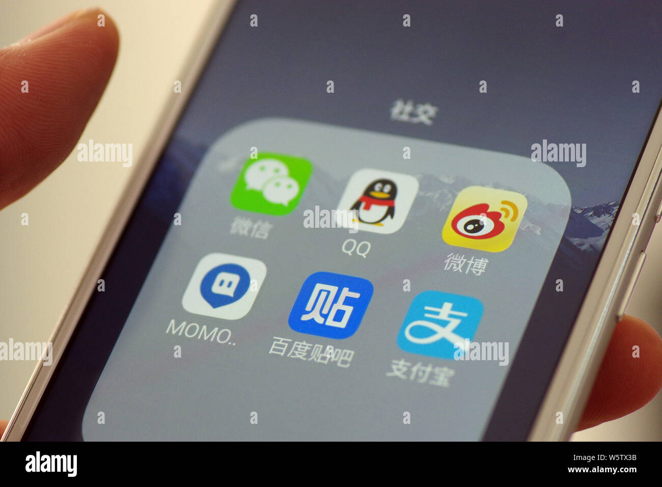 --FILE--un cinese telefono cellulare utente guarda le icone di cinesi social media tra cui mobile piattaforma di social networking Momo, comunicazione cinese Foto Stock