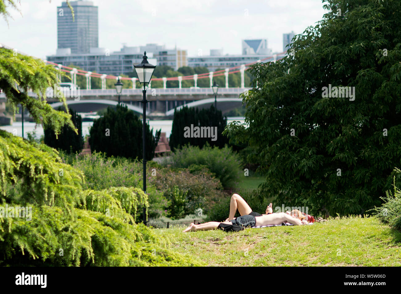29/07/2019. Battersea, Londra, Regno Unito. Prendere il sole sul prato di Battersea Park su una calda e soleggiata giornata Foto Stock