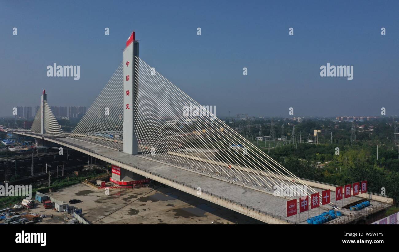 (190730) -- BAODING, luglio 30, 2019 (Xinhua) -- Questa Foto aeree prese sulla luglio 30, 2019 mostra due parti di un ponte al di sopra della ferrovia Beijing-Guangzhou dopo che essi sono ruotate correttamente alle loro posizioni mirate utilizzando la costruzione dello snodo nel metodo di Baoding, nel nord della Cina di nella provincia di Hebei. La Cina ha adottato la struttura girevole metodo nella costruzione di molti ponti per ridurre al minimo le interferenze con il traffico sotto. Il metodo consente di superare i vincoli di ambiente e traffico, mentre un accorciamento del periodo di costruzione. (Foto di Wang Huitang/Xinhua) Foto Stock