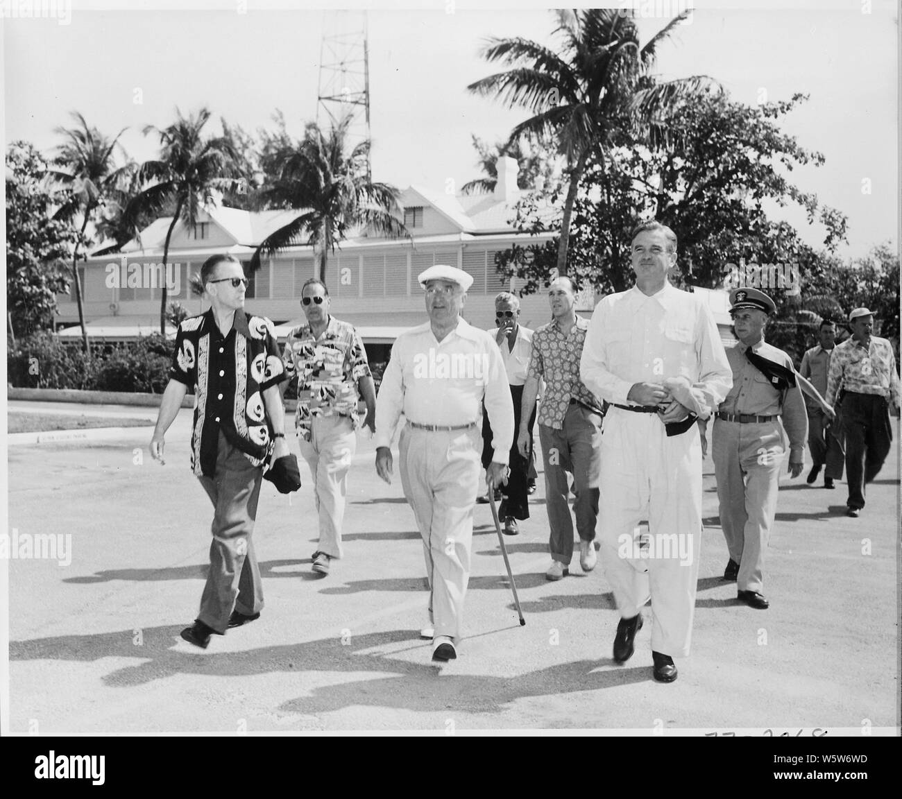 Fotografia del Presidente Truman per la sua passeggiata mattutina alla spiaggia durante la sua vacanza a Key West, Florida, fiancheggiata da Eric Johnston, capo della stabilizzazione economica Amministrazione (sinistra) e W. Stuart Symington, Presidente della Sicurezza Nazionale scheda RISORSE (a destra), con gli altri membri del suo entourage. Foto Stock