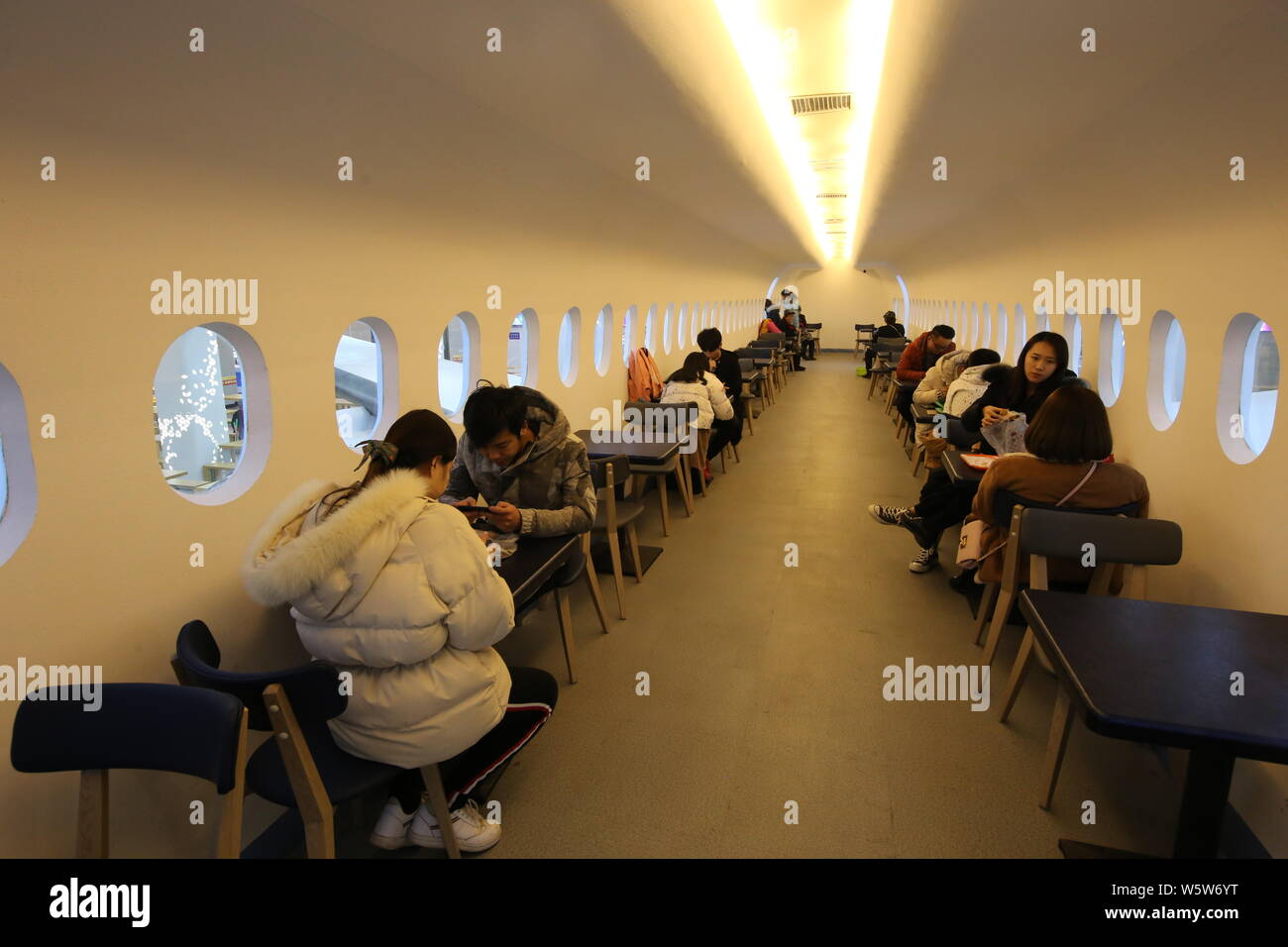 Gli studenti cenare presso un'aviazione mensa a tema decorate con un full-size mock-up del C919 jet del passeggero a Zhengzhou università di aeronautica in Foto Stock