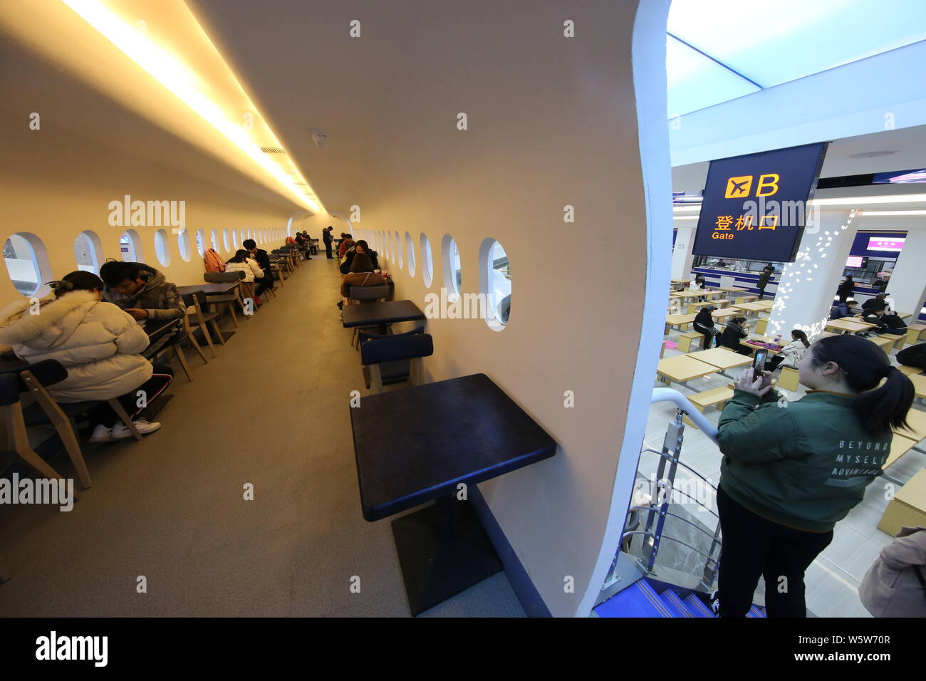 Gli studenti cenare presso un'aviazione mensa a tema decorate con un full-size mock-up del C919 jet del passeggero a Zhengzhou università di aeronautica in Foto Stock