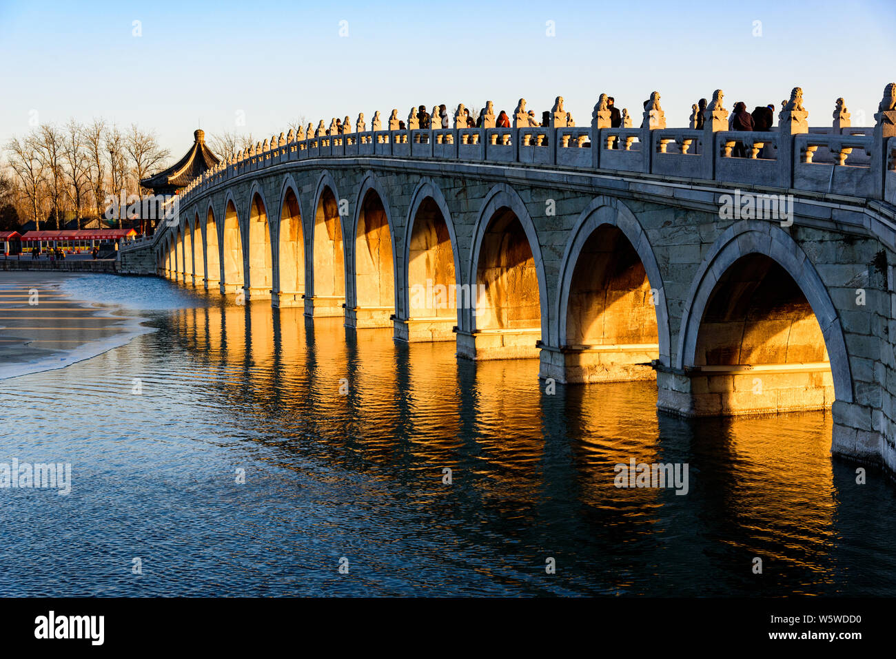 Il crepuscolo dorato penetra attraverso l'apertura del famoso Ponte Seventeen-Arch sotto il tramonto presso il Palazzo estivo a Pechino in Cina, 28 Decem Foto Stock