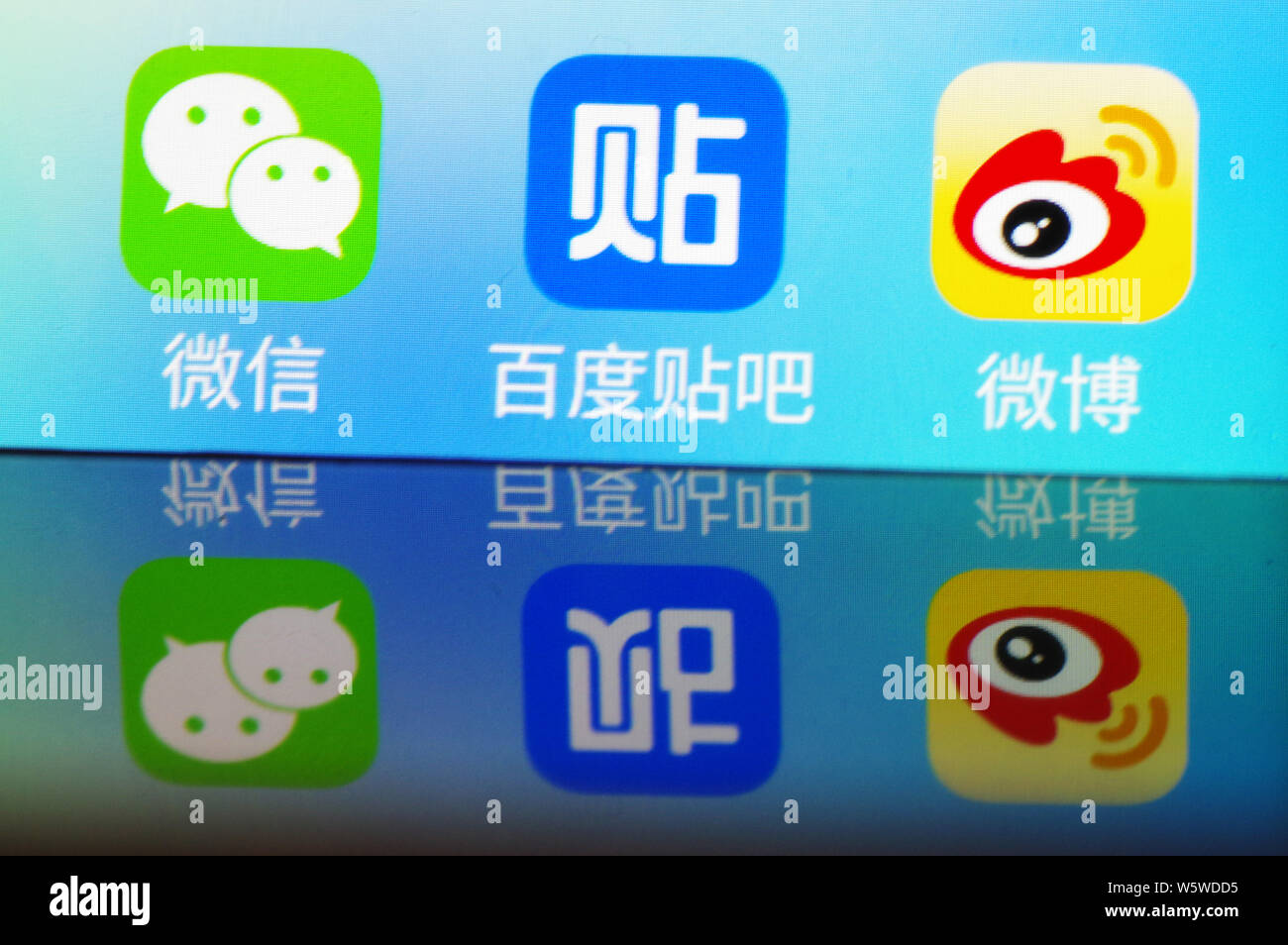 --FILE--un cinese utente del telefono mobile mostra le icone di (da sinistra) messaging app Weixin o WeChat, di Tencent, Baidu Tieba e Weibo, il Twitter-li Foto Stock