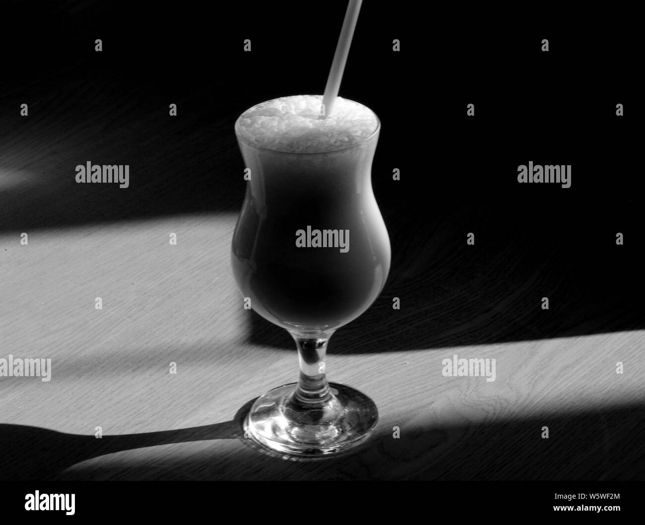 Foto macro di un bianco e nero cocktail gustoso su un tavolo illuminato dal sole. Foto Stock
