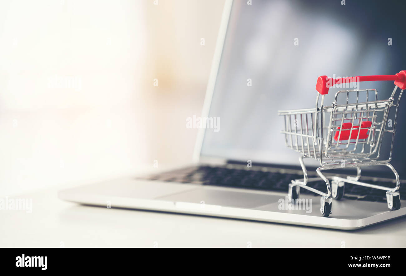 Carrello con laptop sulla scrivania, shopping online concept Foto Stock