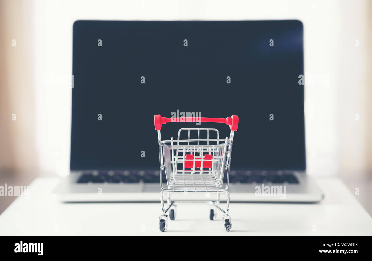Carrello con laptop sulla scrivania, shopping online concept Foto Stock
