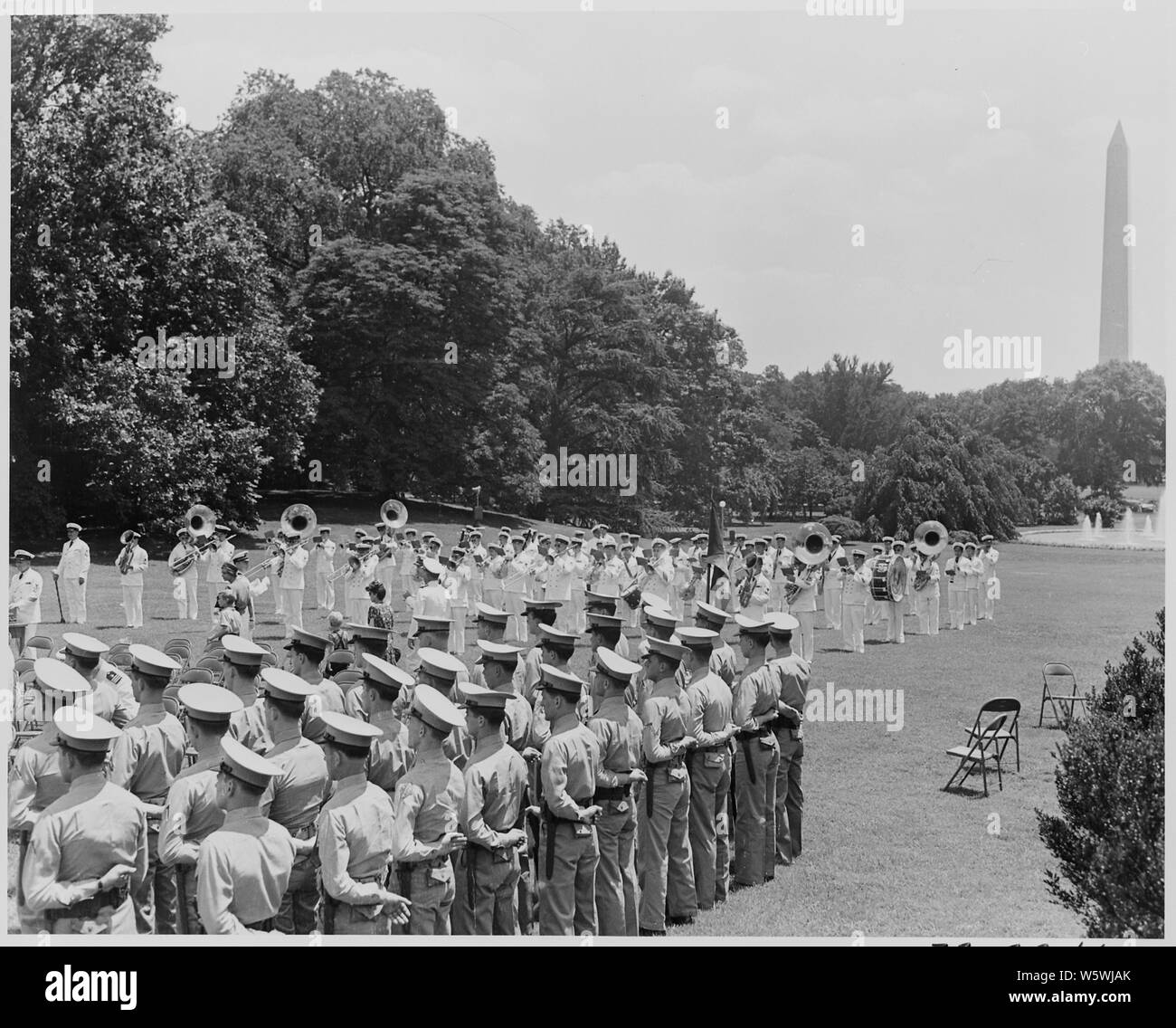Fotografia di una banda militare giocando e truppe in piedi presso l attenzione sulla South Lawn della Casa Bianca, il Monumento di Washington in background durante una cerimonia in cui il Presidente Truman aggiudicato unità presidenziale CITAZIONI DI OTTO STATI UNITI Navy portaerei. Foto Stock