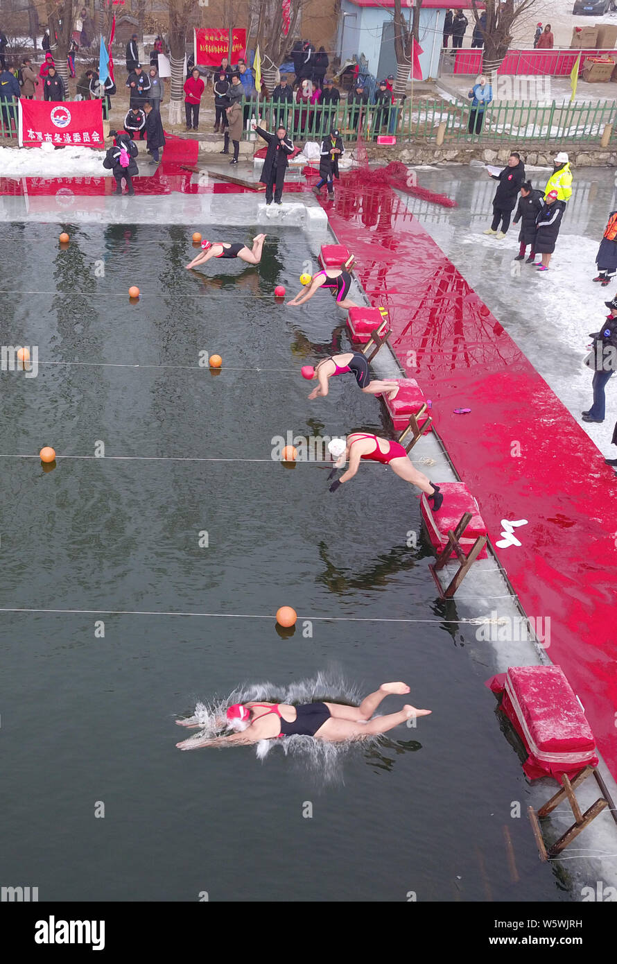 Concorrenti cinesi saltare nell'acqua ghiacciata durante un inverno nuoto la concorrenza nella città di Benxi, a nord-est della Cina di provincia di Liaoning, 23 Dicembre Foto Stock