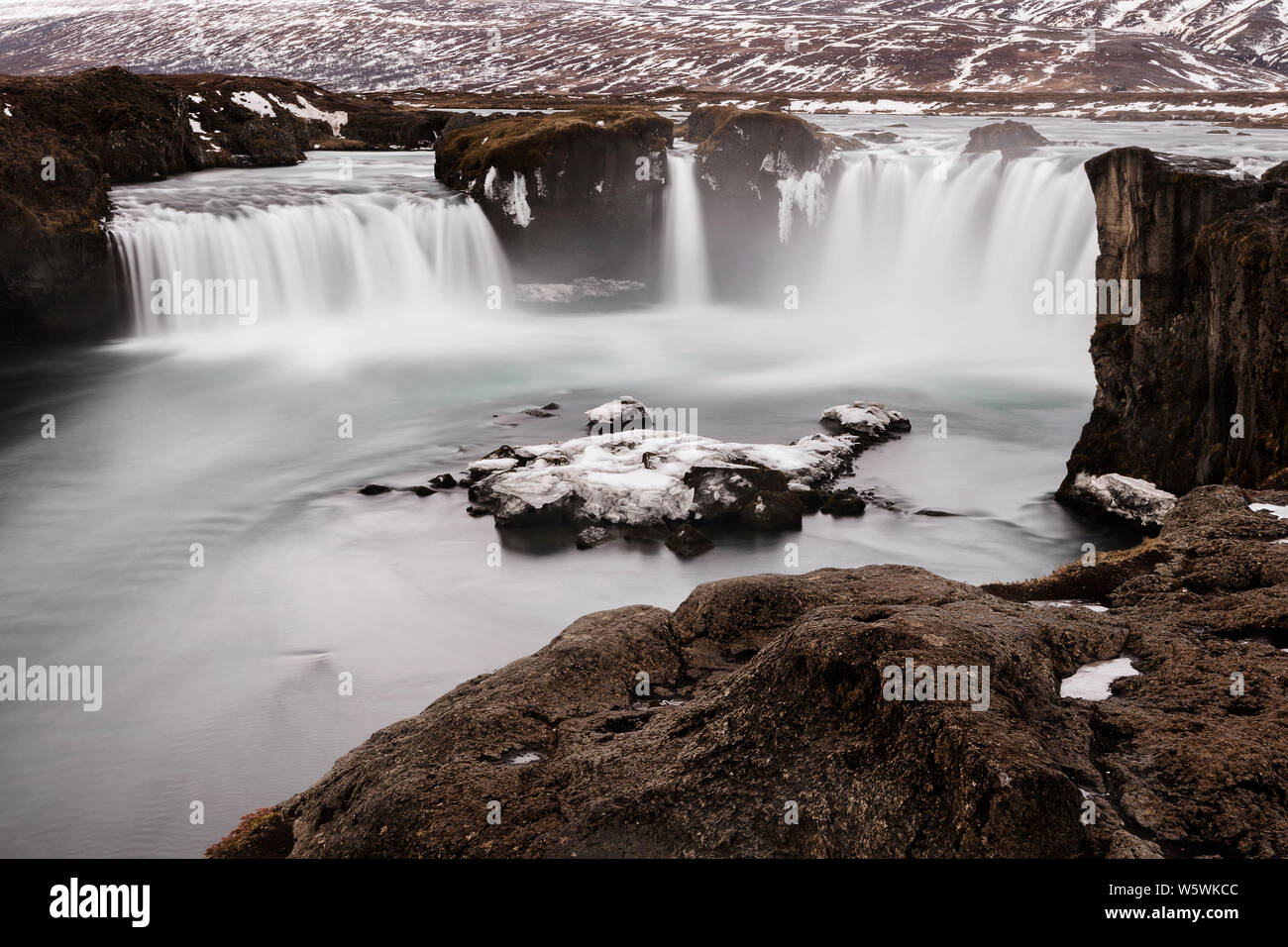 Il ghiacciaio del fuso di acqua che scorre in congelati cascate Godafoss presso sunrise, Islanda Foto Stock