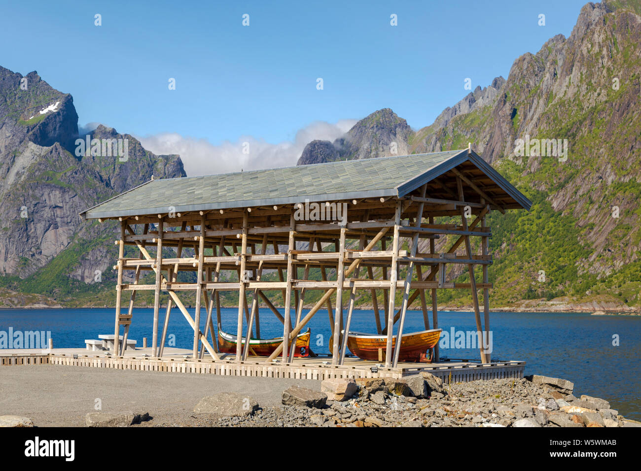 Rack di asciugatura per cod con Nordland BARCHE A Sakrisøy, un villaggio di pescatori, Moskenes, Moskenesøya isola dell'arcipelago delle Lofoten, Norvegia, Foto Stock