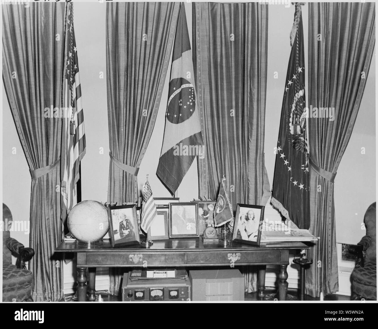 Fotografia della bandiera brasiliana sul display all Ufficio Ovale, e che mostra anche gli oggetti sul tavolo dietro il presidente del banco, comprese fotografie incorniciate del Presidente della moglie, madre e figlia. Foto Stock